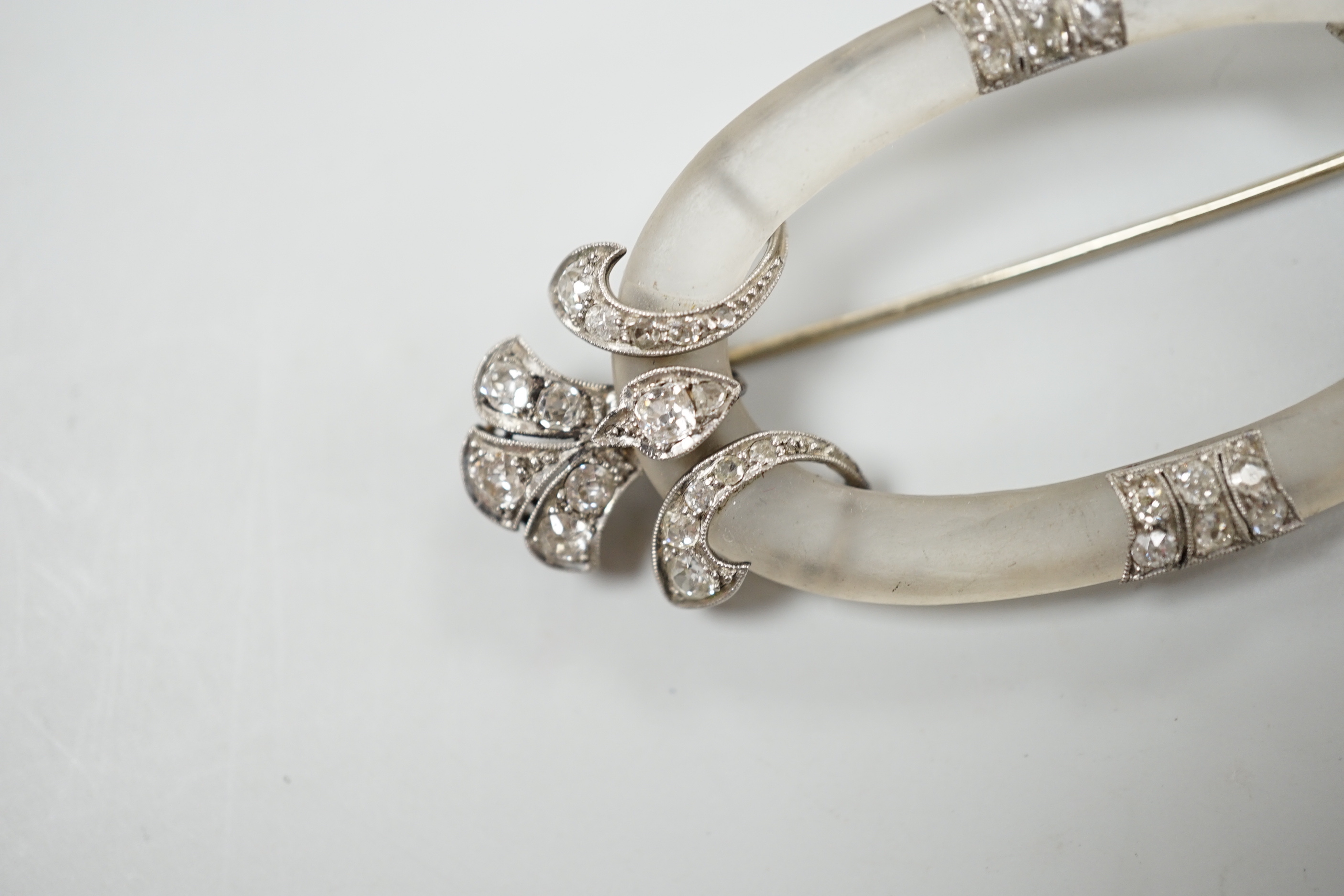 A Belle Epoque diamond set platinum and frosted brooch of open oval form with stylised foliate terminals, width 7cm